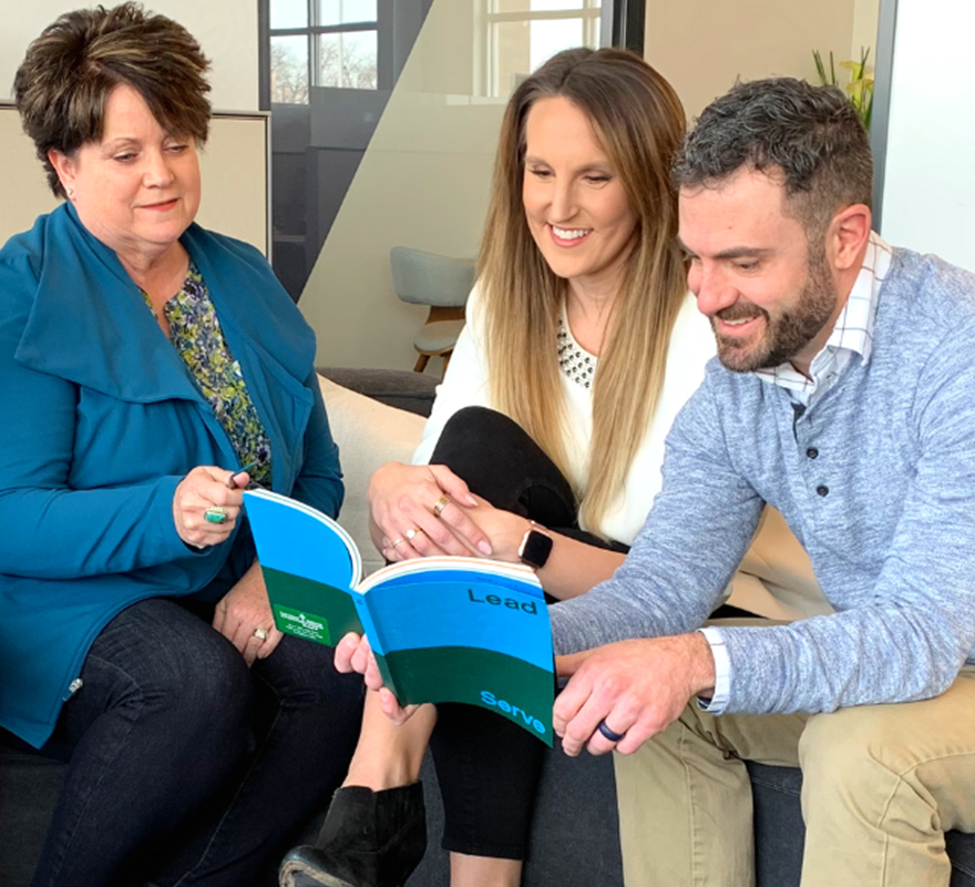 People sitting around looking at a book