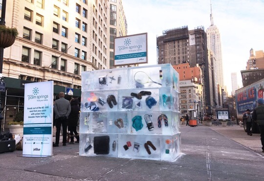 several blocks of ice with California vacation essentials trapped inside on the street in New York